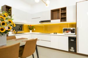 Sleek modern kitchen boasting minimal design and vibrant sunflower arrangement.